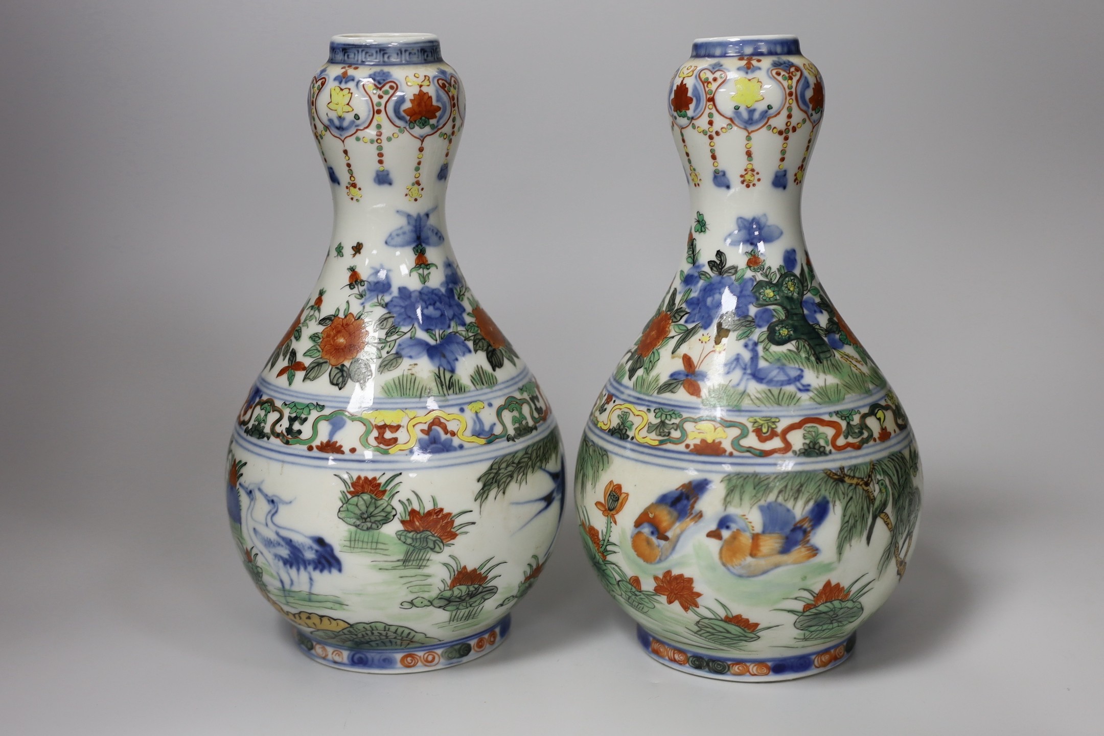 A Chinese style armorial bowl, pair of Chinese clobbered vases and a blue and white plate